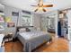 Bedroom features a ceiling fan, bed, and decor for storing shoes and accessories at 12453 Se 61St Ct, Belleview, FL 34420