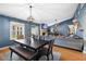 Open-concept dining area with a wooden table, modern lighting, and seamless flow into the living room at 12453 Se 61St Ct, Belleview, FL 34420