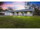 Charming single-story home boasting a well-manicured lawn, a garage, and a durable metal roof at 12453 Se 61St Ct, Belleview, FL 34420