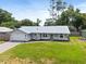 Beautiful single-story home with metal roof, well-manicured lawn, landscaping, and two-car garage at 12453 Se 61St Ct, Belleview, FL 34420