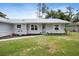 Inviting single-story home with a metal roof, light-grey siding, and a lush green lawn at 12453 Se 61St Ct, Belleview, FL 34420