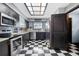 Modern kitchen with black cabinets, stainless steel appliances, and a unique checkerboard floor at 12453 Se 61St Ct, Belleview, FL 34420