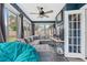 This is a sun room or living room featuring ample windows, a ceiling fan, and stylish decor at 12453 Se 61St Ct, Belleview, FL 34420