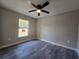 Bedroom features gray flooring, neutral paint, a ceiling fan, and a window at 13 Locust Trak, Ocala, FL 34472
