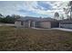 Tan, one-story home with a dark garage door and walkway leading to the front door at 13 Locust Trak, Ocala, FL 34472