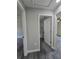 Hallway view featuring a gray wood floor, neutral paint, and leading to the bathroom at 13 Locust Trak, Ocala, FL 34472