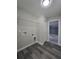 Laundry room features gray wood-look floors, utility connections, and white wire shelving above hookups at 13 Locust Trak, Ocala, FL 34472