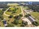 Sprawling horse farm featuring a racetrack, barns, and riding areas surrounded by lush greenery and mature trees at 13800 Ne Jacksonville Road, Citra, FL 32113