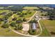 Horse farm with a well-maintained racetrack, multiple outbuildings, and paddocks set amidst green pastures and trees at 13800 Ne Jacksonville Road, Citra, FL 32113