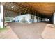 Interior view of the horse barn featuring stalls, hay bales, and a beamed ceiling at 13800 Ne Jacksonville Road, Citra, FL 32113