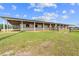 Spacious horse barn with multiple stalls and a covered area, providing shelter and comfort for the animals at 13800 Ne Jacksonville Road, Citra, FL 32113