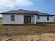 The back exterior of a white single-story home with large windows and a covered patio at 17 Laurel Pass Ln, Ocala, FL 34480