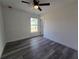 Sunlit bedroom boasts a ceiling fan, gray floors, and a large window with natural light at 17 Laurel Pass Ln, Ocala, FL 34480