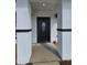 Close up of the front door with elegant black trim, white textured pillars and concrete pathway at 17 Laurel Pass Ln, Ocala, FL 34480