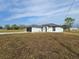 A cozy, single-story house boasting a black garage door, white walls, and expansive green lawn at 17 Laurel Pass Ln, Ocala, FL 34480