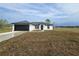 Charming single-story home featuring a black garage door, crisp white exterior, and manicured lawn at 17 Laurel Pass Ln, Ocala, FL 34480