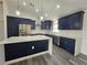 Contemporary kitchen with pendant lighting, navy cabinets, quartz countertop and stainless steel appliances at 17 Laurel Pass Ln, Ocala, FL 34480
