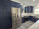 A well-equipped kitchen features stainless steel appliances, navy cabinets, quartz countertop and range hood at 17 Laurel Pass Ln, Ocala, FL 34480