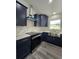 Modern kitchen featuring navy cabinets, stainless steel appliances, and white marble countertops at 17 Laurel Pass Ln, Ocala, FL 34480