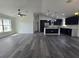 An open-concept living room shows off modern gray floors and connects seamlessly to the beautiful navy kitchen at 17 Laurel Pass Ln, Ocala, FL 34480