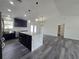 Open-concept living space with kitchen island, pendant lights, and sleek gray flooring at 17 Laurel Pass Ln, Ocala, FL 34480