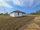 Side angle view of a white single-story home with dark trim and lots of green space at 17 Laurel Pass Ln, Ocala, FL 34480