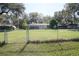 Expansive backyard with a chain-link fence and a screened enclosure, offering privacy and outdoor space at 1764 Se 169Th Avenue Rd, Silver Springs, FL 34488
