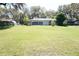 Spacious backyard featuring a screened-in enclosure, lush green grass, and mature trees at 1764 Se 169Th Avenue Rd, Silver Springs, FL 34488
