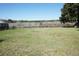 Spacious backyard bordered by a chain-link fence, offering serene views of a tranquil creek at 1764 Se 169Th Avenue Rd, Silver Springs, FL 34488