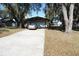 Front exterior of the property features mature trees, a driveway and a two-car garage at 1764 Se 169Th Avenue Rd, Silver Springs, FL 34488