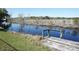 Scenic waterfront view featuring a weathered wooden dock and calm, reflective waters at 1764 Se 169Th Avenue Rd, Silver Springs, FL 34488