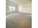 Spacious bedroom with plush carpeting, tray ceiling, and a large window offering ample natural light at 19444 Sw 78Th Pl, Dunnellon, FL 34432