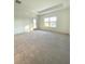 Bright, carpeted bedroom with a tray ceiling, large window, and easy access to the outdoors at 19444 Sw 78Th Pl, Dunnellon, FL 34432
