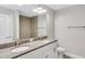 Well-lit bathroom featuring a double vanity with granite countertops and a large mirror reflecting a tiled shower at 211 Oak Lane Cir, Ocala, FL 34472