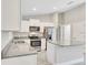 Modern kitchen featuring white cabinets, stainless steel appliances, and granite countertops at 211 Oak Lane Cir, Ocala, FL 34472