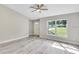 Bright living room with gray vinyl floors and a large window providing ample natural light at 211 Oak Lane Cir, Ocala, FL 34472