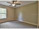 Neutral bedroom with plush carpet, a ceiling fan, and a window with a view of the outdoors at 23458 Nw Amberjack Ave, Dunnellon, FL 34431