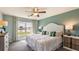 Bright main bedroom featuring a ceiling fan, large window with curtains, and stylish furnishings at 2426 Sw 168Th Loop, Ocala, FL 34473