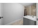 Bathroom featuring a shower with tile surround, a gray vanity and an framed mirror at 3010 Sw 137Th Pl, Ocala, FL 34473