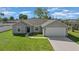 Charming single-story home featuring a two-car garage, well-manicured lawn, and a welcoming walkway to the front door at 3010 Sw 137Th Pl, Ocala, FL 34473