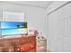 Well-lit bedroom with closet, dresser, and wall-mounted television for entertainment and storage at 307 Nw 10Th Ave, Ocala, FL 34475