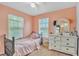 Bright bedroom features two windows, a white dresser, a mirror, and a twin-sized bed at 307 Nw 10Th Ave, Ocala, FL 34475