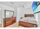 Cozy bedroom showcasing a wooden bed frame, dresser, ceiling fan, and a wall-mounted television at 307 Nw 10Th Ave, Ocala, FL 34475
