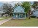 Charming two-story home with a light blue exterior, inviting front porch, and well-manicured lawn at 307 Nw 10Th Ave, Ocala, FL 34475