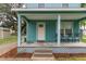 Inviting front porch featuring light blue exterior siding, seating, and lattice detailing around the base at 307 Nw 10Th Ave, Ocala, FL 34475