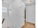 Bright hallway with neutral carpet and white walls, door leading into a bathroom at 307 Nw 10Th Ave, Ocala, FL 34475