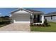Charming single-story home with a two-car garage and stone accents and a brick paver driveway at 4040 Nw 44Th Cir, Ocala, FL 34482