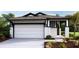 Beautiful exterior featuring white siding, a two-car garage, and inviting landscaping at 4040 Nw 44Th Cir, Ocala, FL 34482