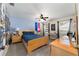 Cozy bedroom with blue accent wall, light wood furniture, ceiling fan, and two windows at 4245 Se 24Th Ter, Ocala, FL 34480