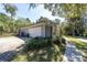 Side view of a single-story home featuring a two-car garage and mature landscaping at 4245 Se 24Th Ter, Ocala, FL 34480